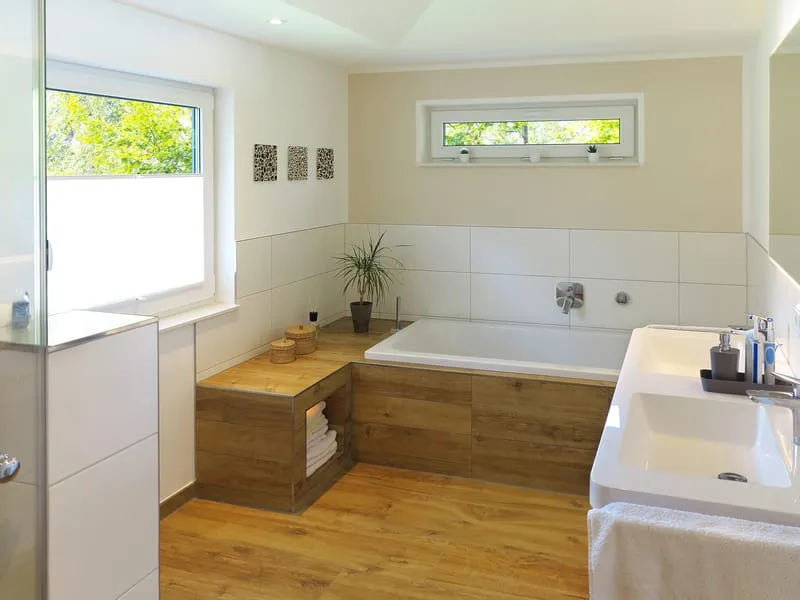 Helles Badezimmer mit Fliesen in Holzoptik und weissen Wandfliesen.