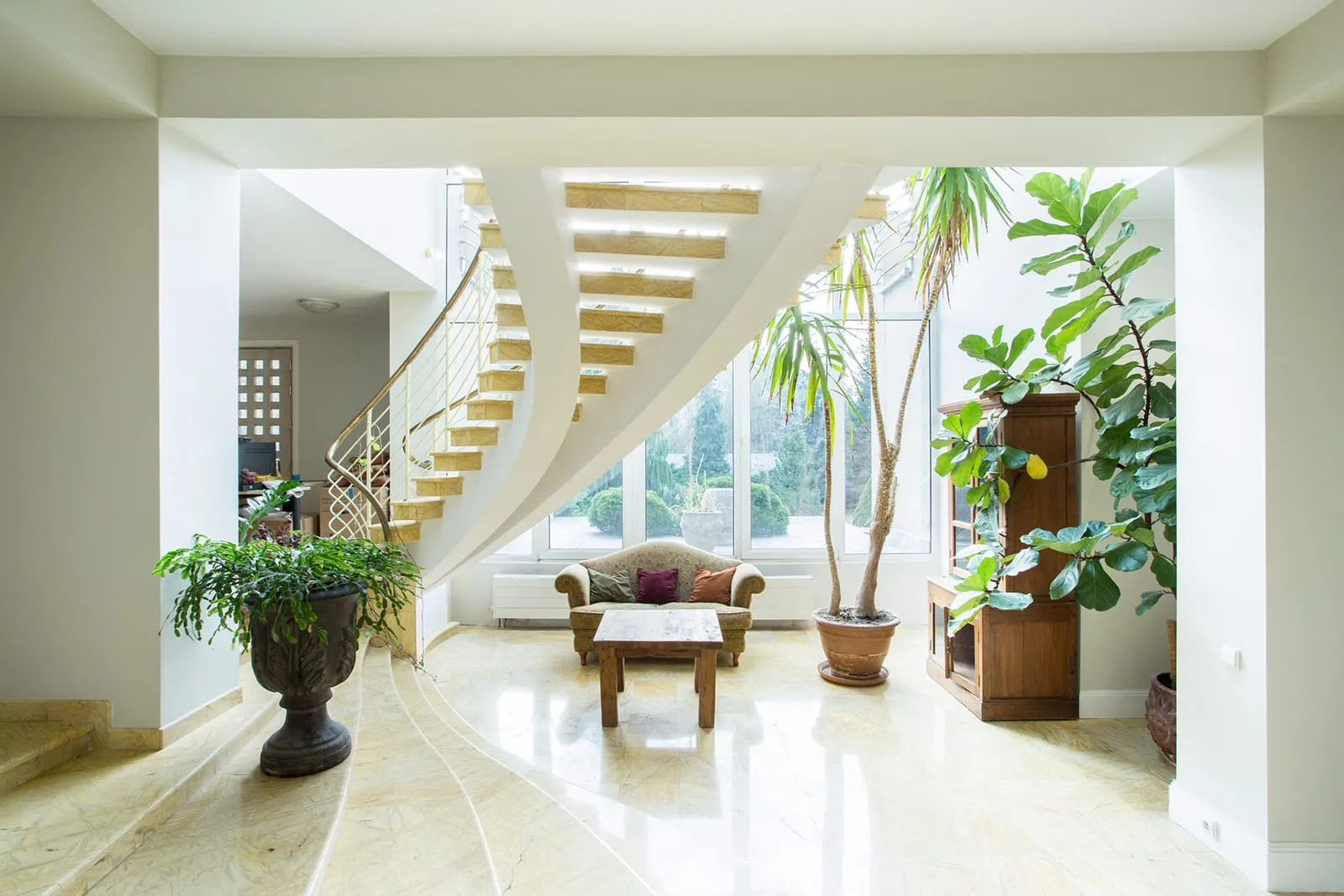 Ein verfliestes und helles Wohnzimmer mit Treppe und Sofa