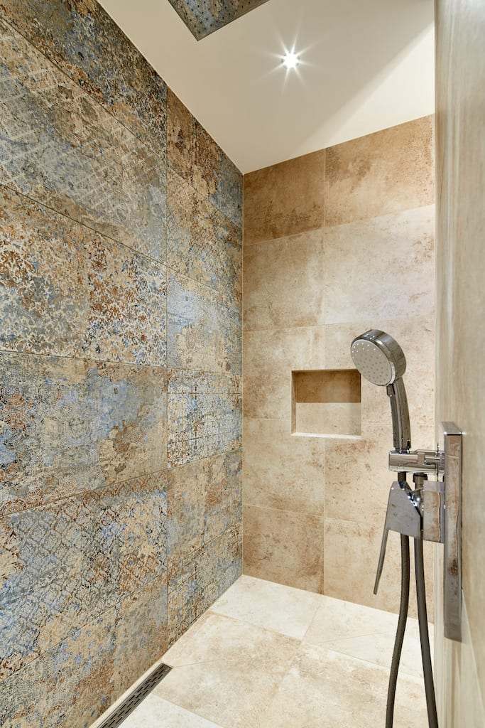 Dusche mit Wandfliesen in Natursteinoptik und eingelassener Ablage