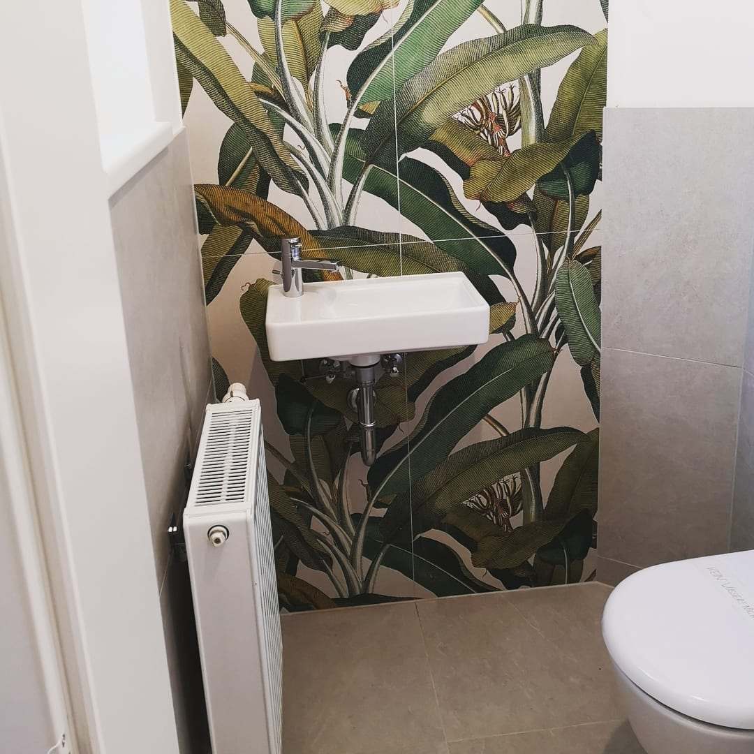 Gäste-WC mit Waschbecken vor einer Wand mit Blättertapete