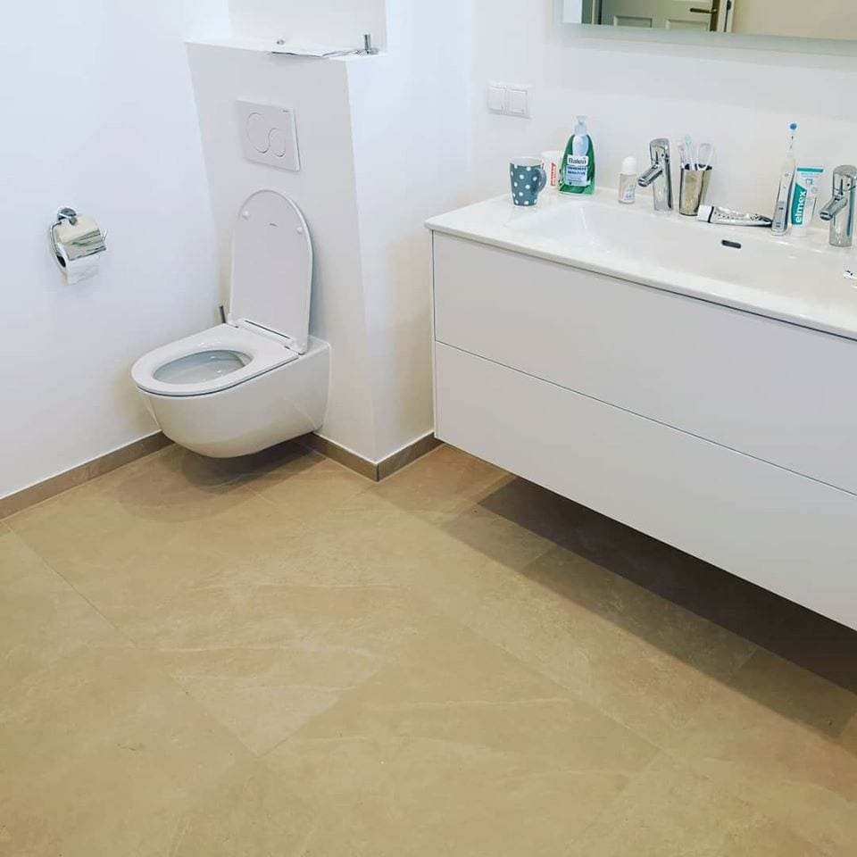 WC mit Hänge-WC, weissem Waschtisch und beigem Fliesenboden