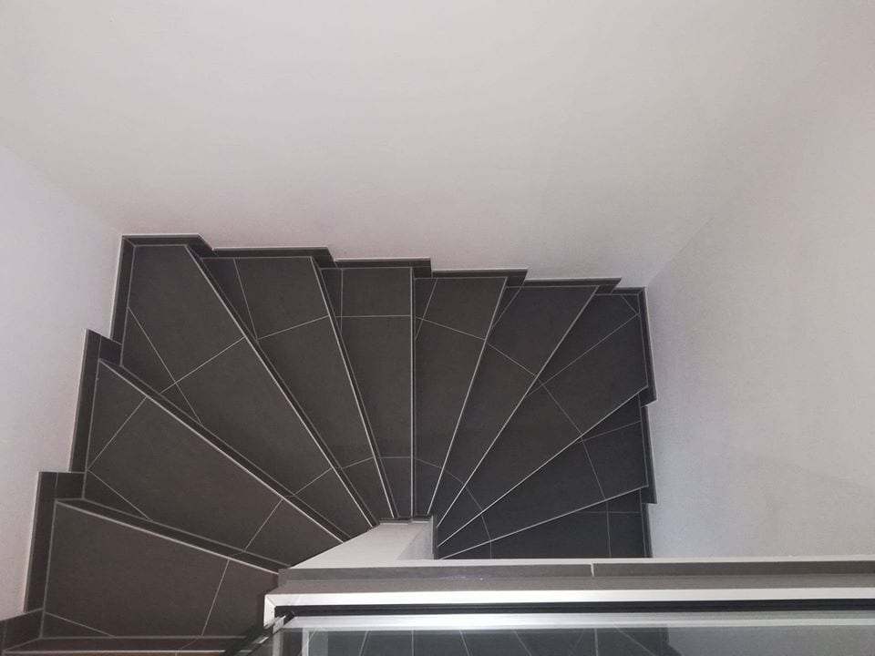 Wendeltreppe mit dunklem Fliesenbelag